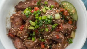 A dish of bulgogi beef in a white bowl with sesame seeds and scallions, showing different serving ideas and toppings.