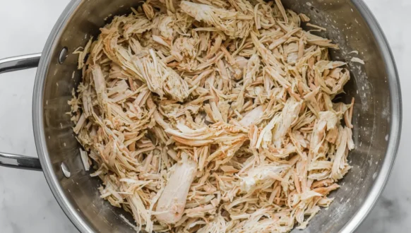 Shredded chicken in a bowl ready for use in shredded chicken recipes like tacos, salads, or casseroles.