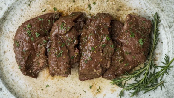 Pan-seared beef liver slices garnished with herbs, a healthy and flavorful addition to any beef liver recipe.