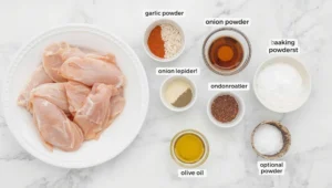Ingredients for baked chicken legs recipes including drumsticks, spices, olive oil, and seasoning blends arranged on a board.